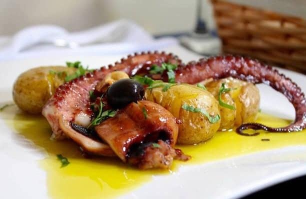 Danie kuchni portugalskiej polvo a lagareiro ośmiornica z pieczonymi ziemniakami i czosnkiem